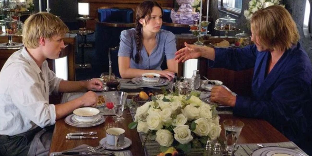 Peeta Katniss and Haymitch talk at the table on the train in The Hunger Games