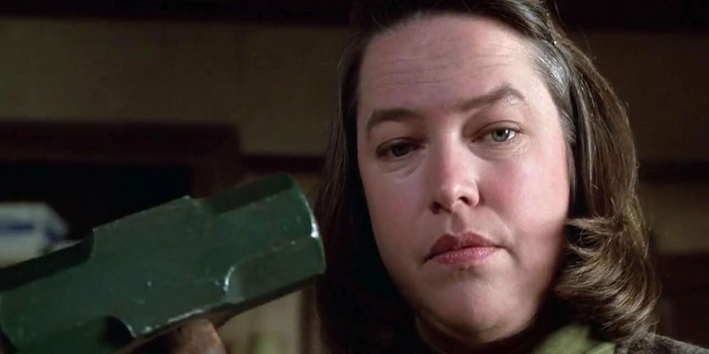 Annie Wilkes in Misery holding up a large hammer