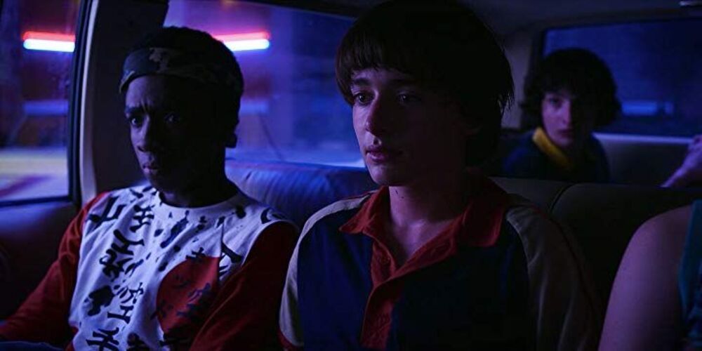 Lucas and Will sitting in a car in Stranger Things